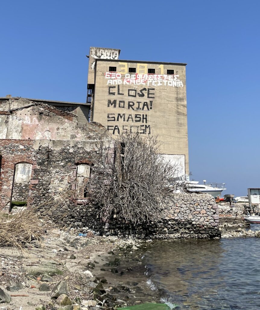 Abandoned building in Lesvos with the black lettering saying "Close Moria, smash Fascism"